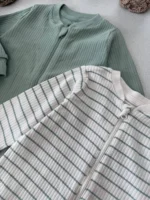 نمای نزدیک از یقه اسپرت و زیپ سرهمی نوزادی کبریتی H&M رنگ سبز و راه‌راه