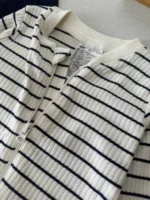 جزئیات یقه، زیپ و مارک سرهمی نوزادی H&M طرح راه‌راه سفید و مشکی