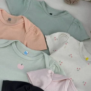نمای نزدیک بادی نوزادی دخترانه H&M با سرشانه چیندار در رنگ‌های پاستلی سبز سدری، هلویی و صورتی با طرح گیلاس